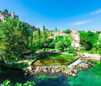 The river Sorgue in Fontaine de Vaucluse in the background the castle ruins from Philp Cabassole. Vaucluse, Provence, France, Europe