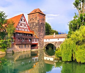 Nuremberg, Germany, beautiful old bridge with medieval tower and half timbered house along the river with reflections